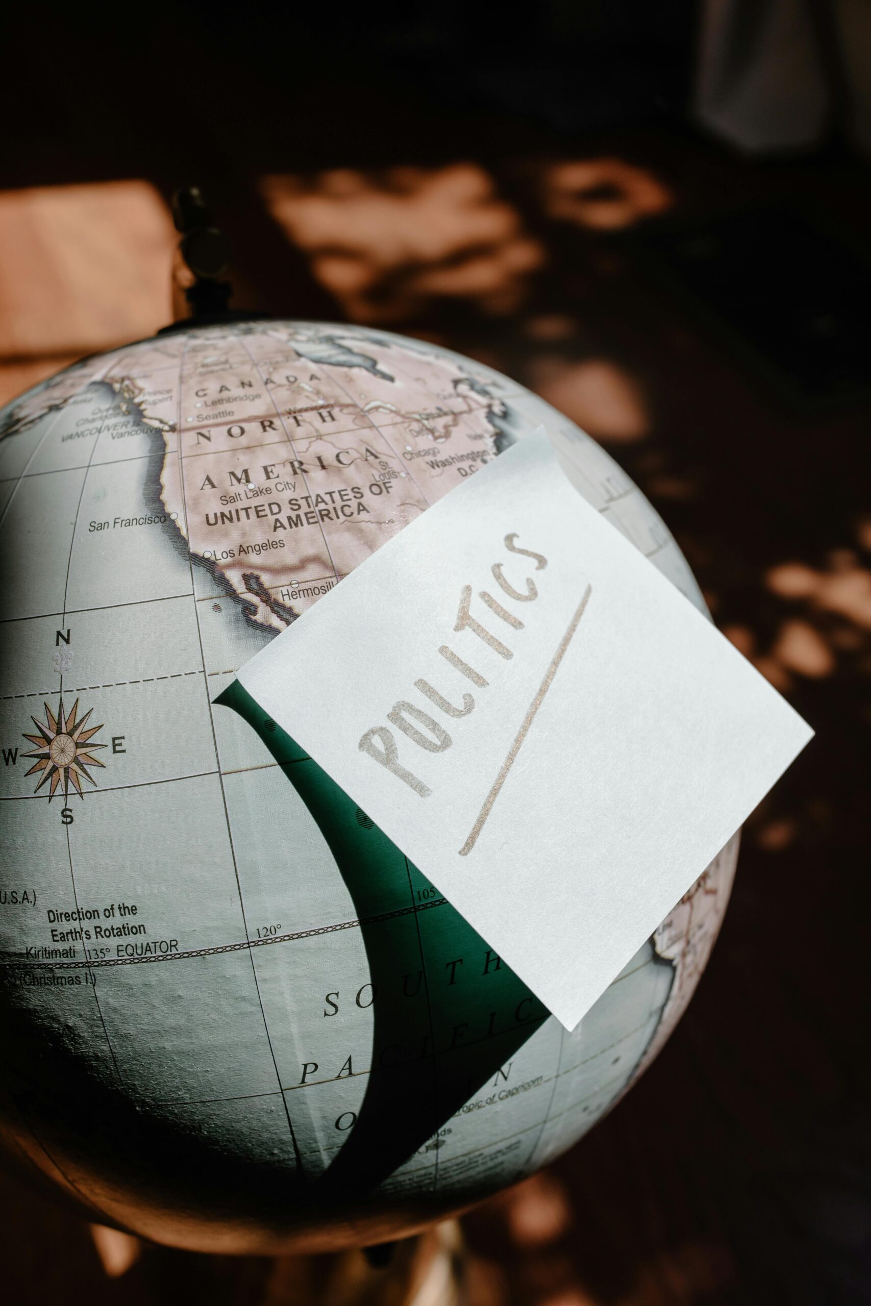 A globe focused on the USA with a sticky note reading 'Politics'.